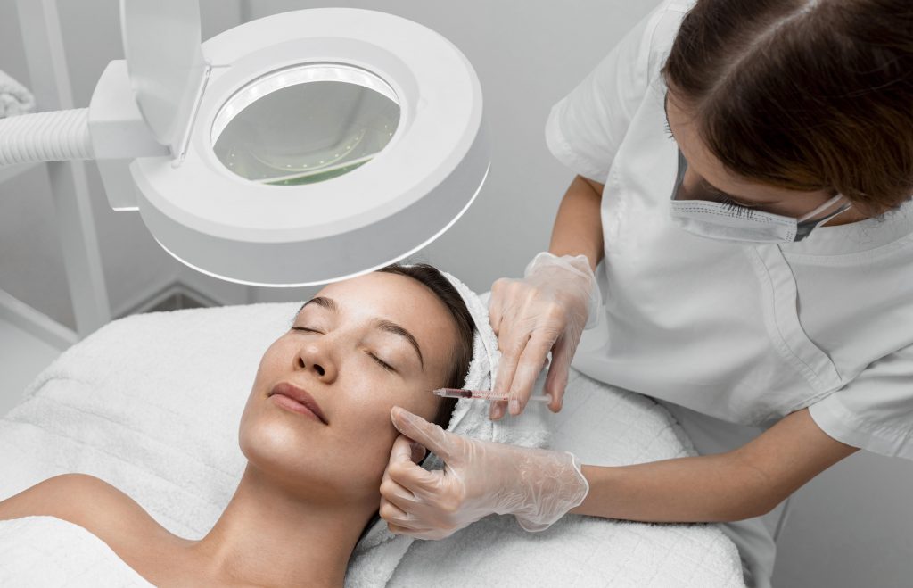 Mujer recibiendo tratamiento de Inyección de mesoterapia facial para reponer nutrientes indispensables para la piel en nuestra clínica en Sevilla.