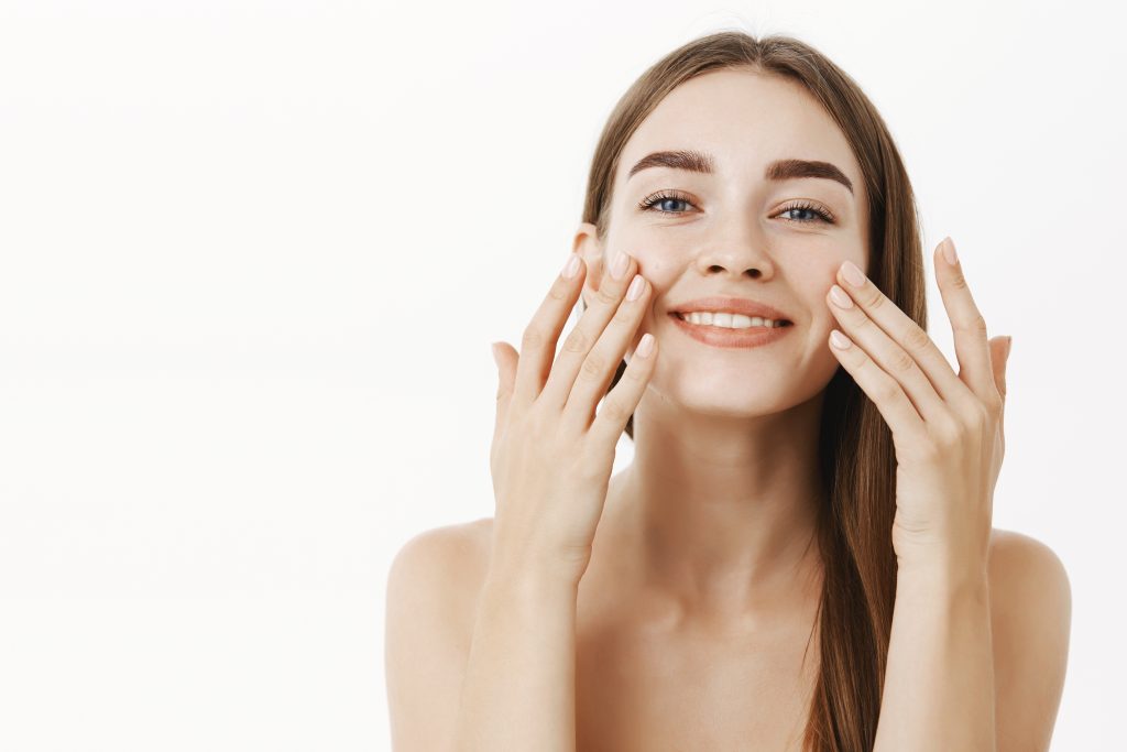 Mujer sonriente con la piel tersa y rejuvenecida después de recibir tratamiento facial de Microleending que regenera la piel mediante inducción de colágeno